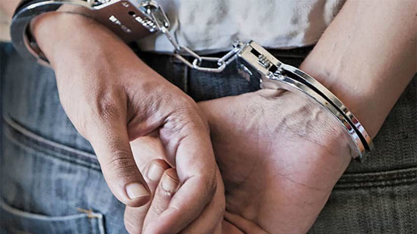 A close-up shot of a pair of handcuffs around someone's wrists, indicating an arrest for domestic violence