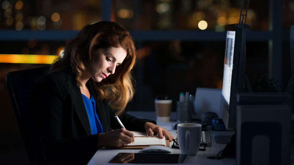 workaholic professional business woman working late at night at the office