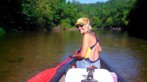 Kristine Lawless canoeing on a river, enjoying her retirement